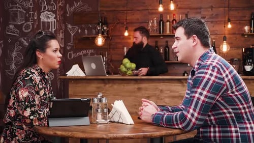 Couple Talking in Coffee Shop While Ordering Food