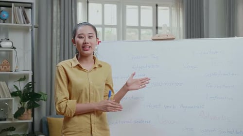 Woman Explains Grammar Lesson at Whiteboard