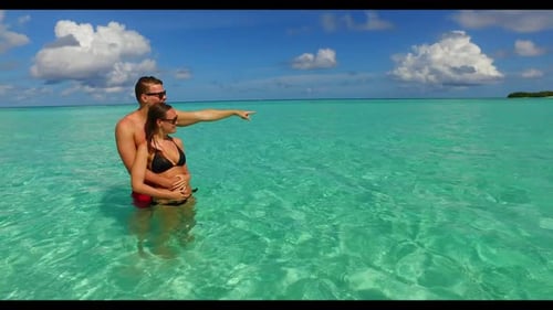Man and woman happy together on marine bay beach journey by aqua blue ocean and white sand backgroun