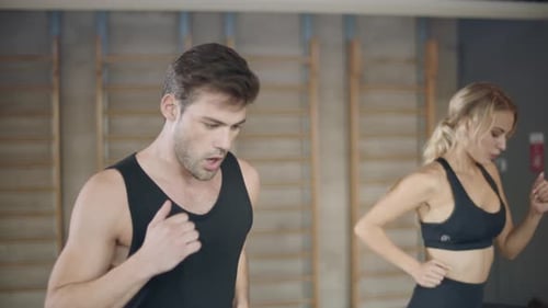 Tired Trainers Finishing Cardio Exercise on Run Machine in Fitness Center