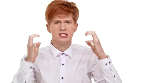 Jeune homme caucasien roux en colère debout sur fond blanc prêt à se battre au ralenti