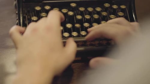 Weibliche Hände tippen langsam auf der alten Schreibmaschine mit russischen Buchstaben