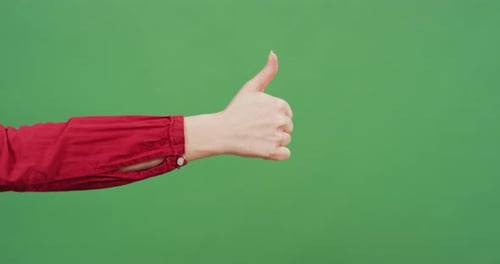 Hand giving thumbs up on green screen
