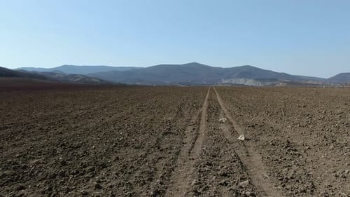 Voler au-dessus d'une terre labourée au milieu des montagnes