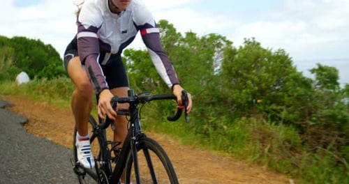 Female cyclist cycling on a countryside road 4k