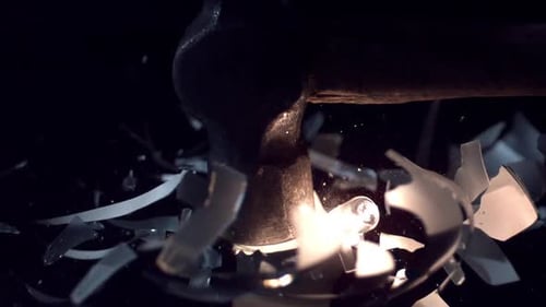 Slow motion of light bulb shattering from hammer hitting it.