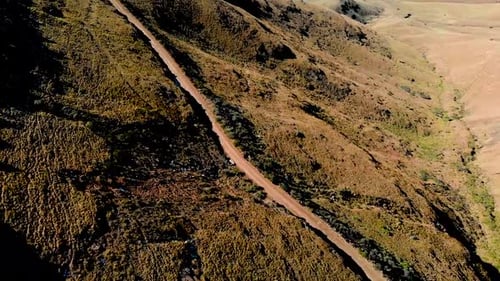 Luftaufnahme folgt Mountainbikern, die einen Gebirgspass hinunterfahren 60 fps