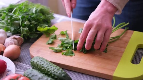 Woman Chopping Fresh Parsley on Cutting Board