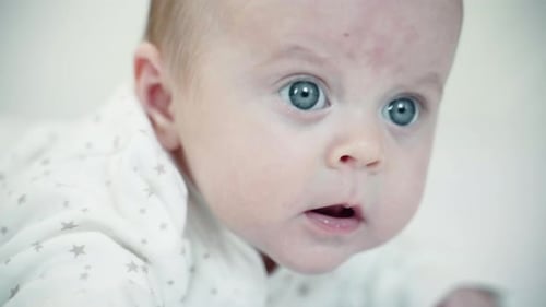 Newborn Baby Toddler 4 Months Age Lying On Bed In Bedroom At Home