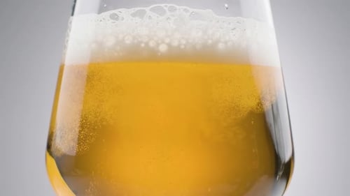 Slow motion, Close up shot Fresh Beer pouring into glass, white background