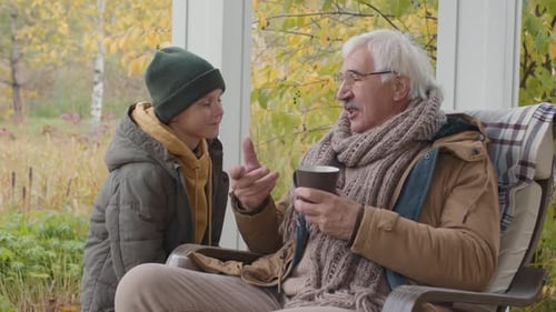 Kid Talking to Granddad Sitting on Terrace