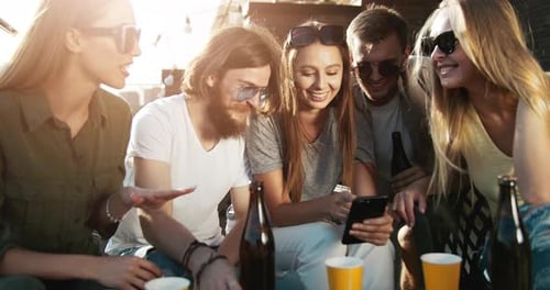 Young Adults Looking at Smartphone at Outdoor Party