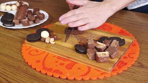 Manos cortando barras de chocolate en trozos