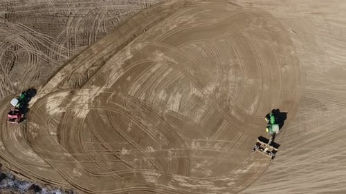 Aerial View of Tractors Making Patterns in Field
