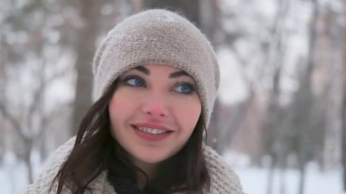 Portrait of a Beautiful Girl with Blue Eyes Posing in a Winter Park in a Good Mood. Camera Movement
