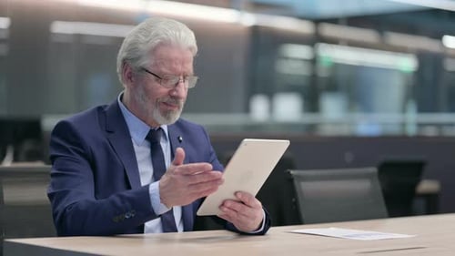 Mature Businessman Working on Tablet in Office
