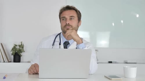 Pensive Doctor Sitting in Clinic and Thinking