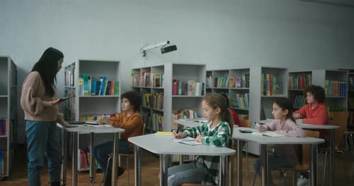 Asian Teacher Uses Tablet Checking Learning Process of Kids