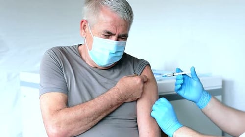 Senior Man Receiving Injection in Clinical Setting