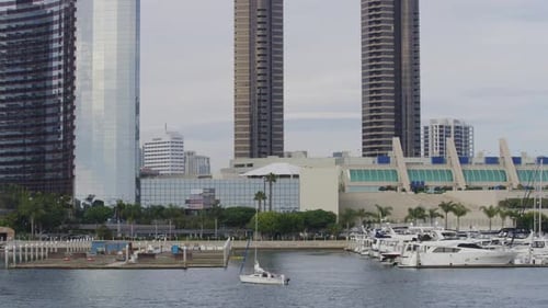 Scenic City Waterfront with Sailboat and Towers