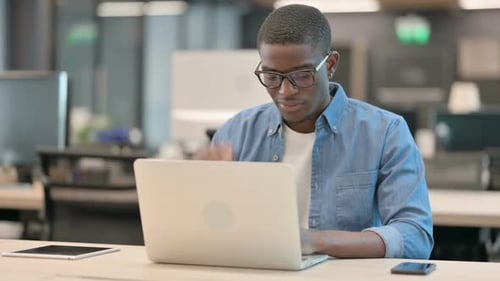 Young Adult Stretching Neck at Office Desk