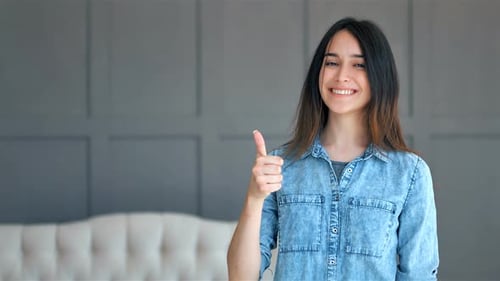 Young Woman Gives Thumbs Up and Smiles
