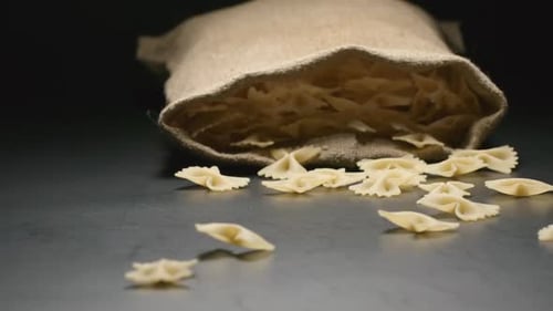 Cloth bag falls and pasta (farfalle) fall out of him