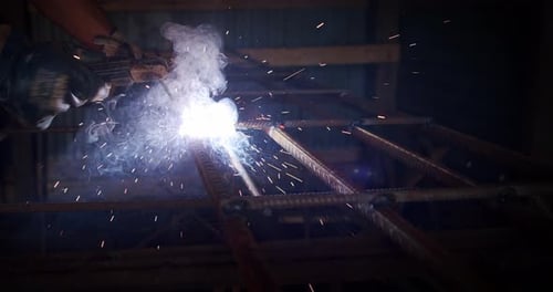 Slow Motion. Welder Welding The Worker Performs Metal Welding at the Factory or Construction Site