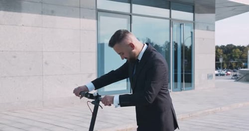 Positive Businessman Enjoying Ride on Electric Scooter in Office Area