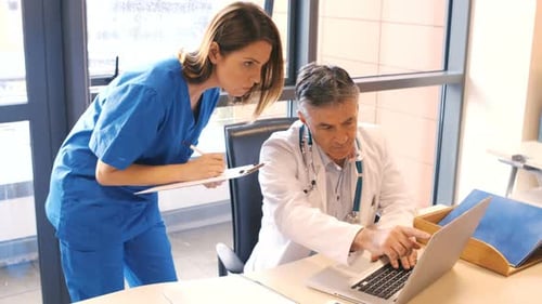 Doctor and Nurse Working Together in Hospital Office