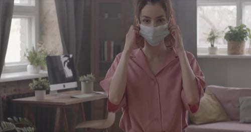 Woman Takes Off Surgical Mask in Living Room