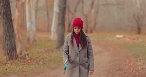 Woman Walking in Autumn Park With Leash