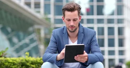 Man Uses Tablet Device in Urban Environment
