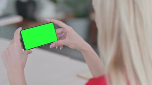 Young Blonde Woman Using Smartphone with Green Chroma Key Screen