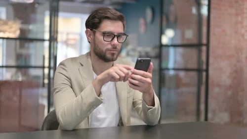 Man Using Smartphone in Modern Office Setting
