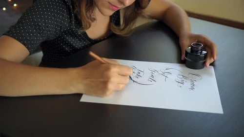 Close Up Shot of a Young Woman Calligraphy Writing on a Paper Using Lettering Technique
