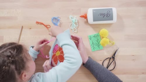 Child and Woman Creating Flower Banner with Yarn