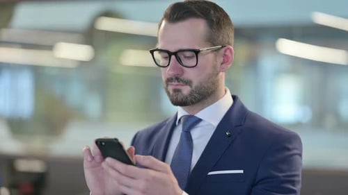 Serious Man in Suit Using Mobile Phone