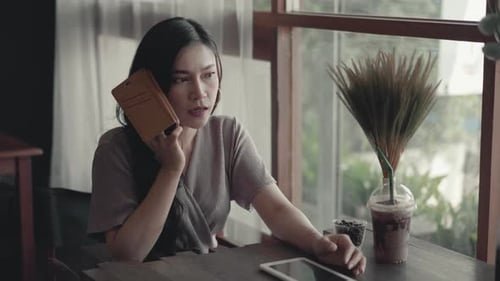 Woman Talking on Phone in Urban Cafe