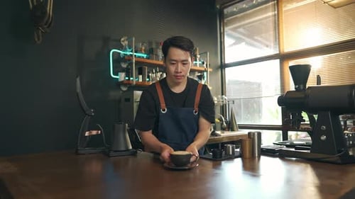 Barista Holding Coffee at Coffee Shop