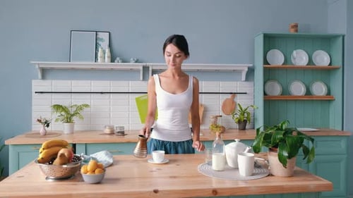 Woman Pours Coffee in Bright Kitchen
