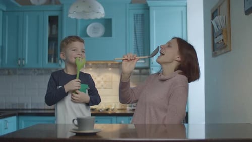Mother and Son Singing and Dancing Together at Home