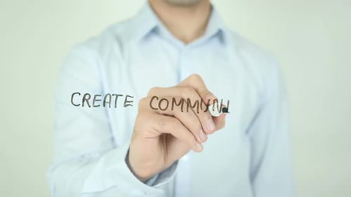 Person Writes Create Community on Glass Surface