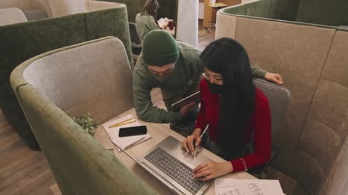 Des collègues de travail discutent du travail dans un stand au bureau