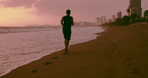 Jeune homme caucasien s'entraînant à l'extérieur sur fond de coucher de soleil violet-orange et magnifique