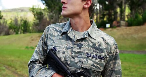 Young Adult Soldier Holding Rifle Outdoors