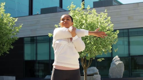 Athletic Woman Stretching Arms in Urban Environment