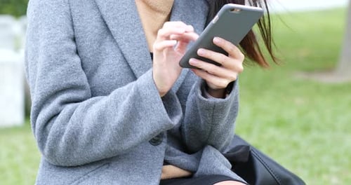 Woman Typing on Cell Phone Outdoors