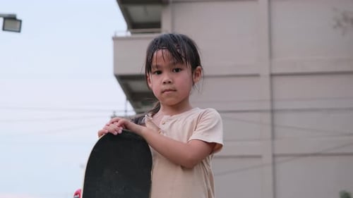 Little girl playing with skateboard. Little school girl posing with skateboard.