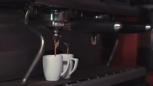 Coffee Pouring Into Mugs From Espresso Machine